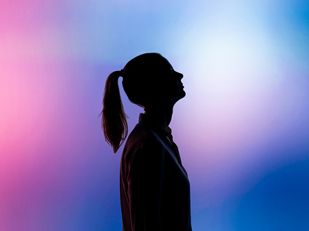 A silhouette of a person against a blue and pink background.
